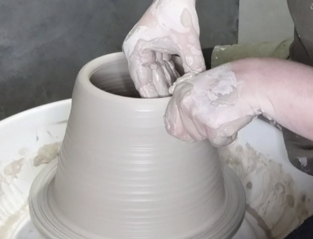 Manos modelando barro en el torno de alfarero durante taller de cerámica en Jerez